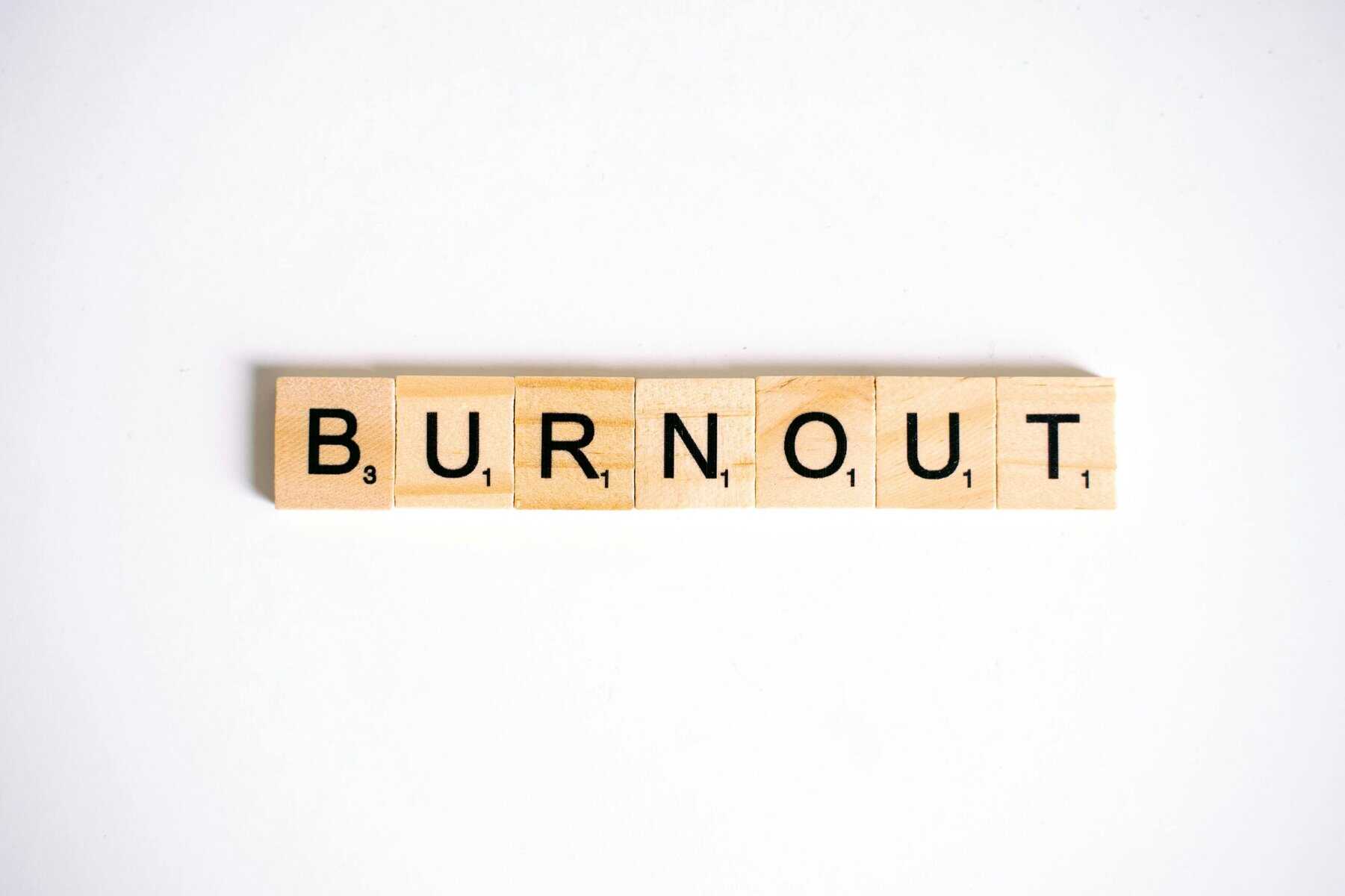 Image of wooden scrabble tiles spelling out "Burnout" on white background